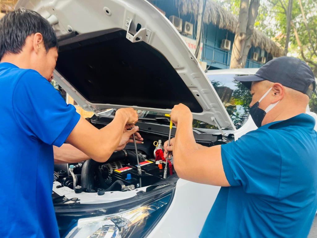 Nhân viên đang thay ắc quy ô tô cho khách hàng